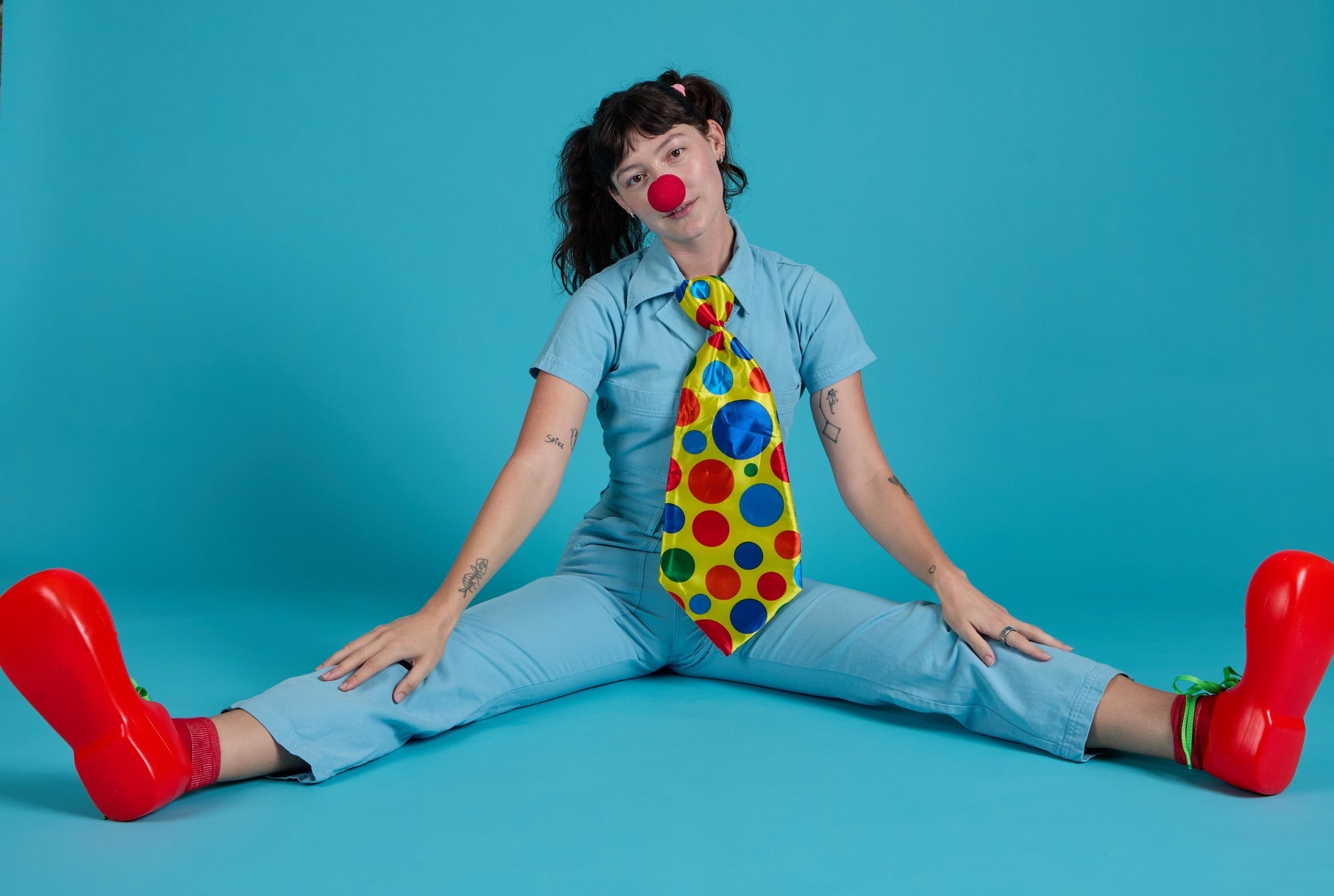 Alex is wearing the Short Sleeve Jumpsuit in Baby Blue accessorized as a clown