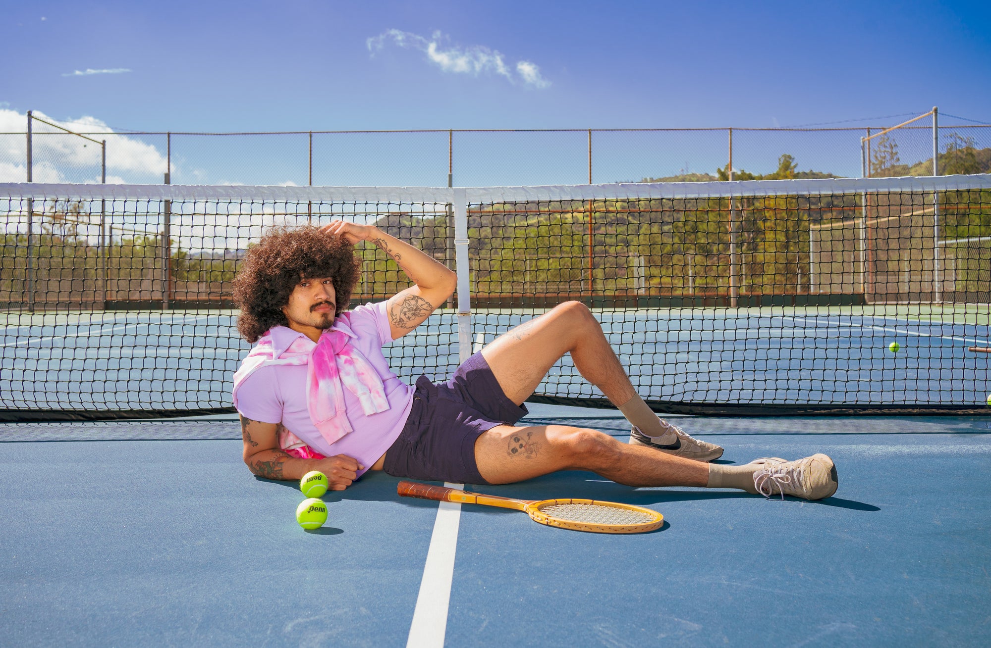 Jesse wearing Fisherman Polo in Lilac Purple, Work Shorts in Navy Blue with Tie-Dye Hoodie in pink