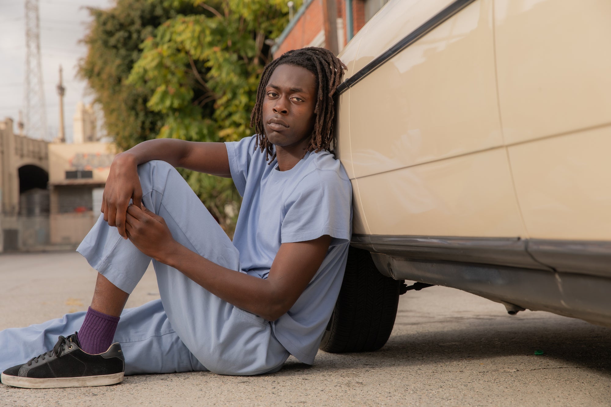 Malcom is wearing The Organic Vintage Tee in Periwinkle and Heavyweight Trousers in Periwinkle