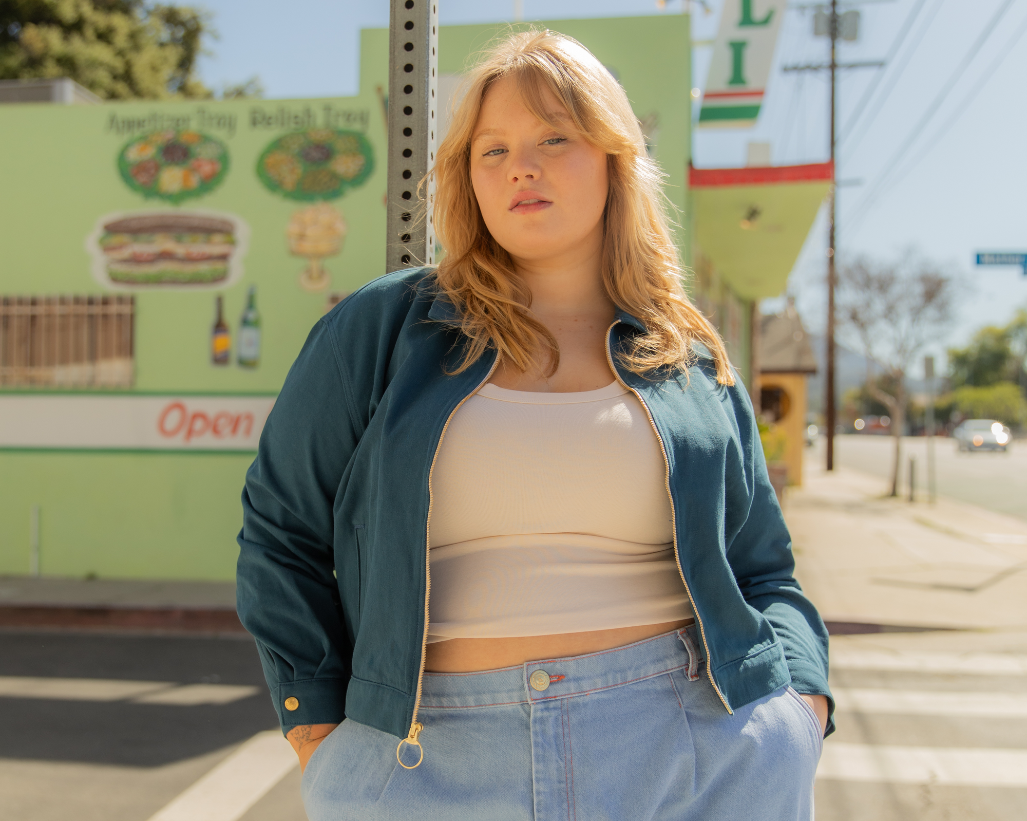 Juliet is wearing Ricky Jacket in Lagoon, Cropped Cami in Vintage Tee Off-White, and Indigo Wide Leg Trouser in Light Wash