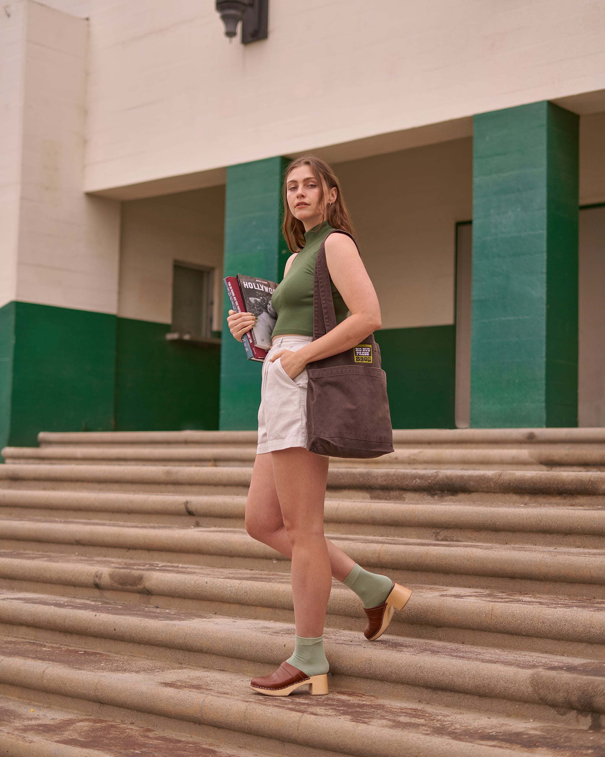 Allison wearing Sleeveless Essential Turtleneck in Dark Emerald, Trouser Shorts in Dishwater White and Everyday Tote in Espresso Brown
