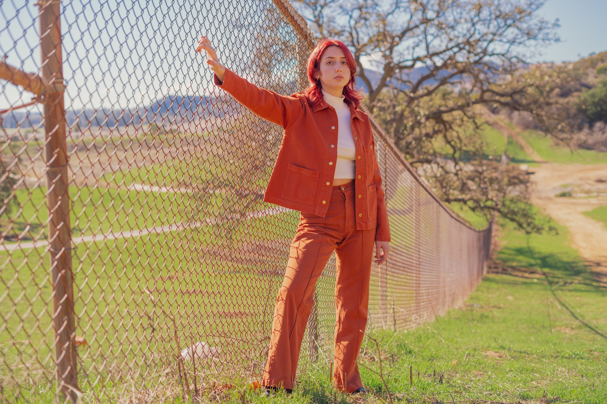 Betty wearing Work Jacket in Burnt Terracotta, Sleeveless Essential Turtleneck in Vintage Off-White, and Western Pants in Burnt Terracotta