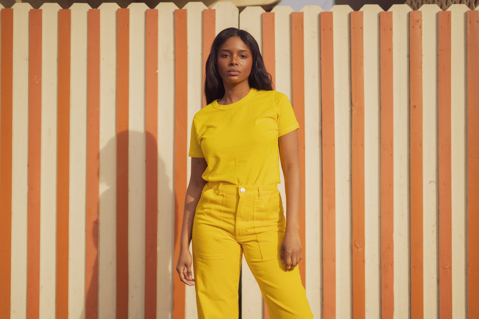 Kandia is wearing JV Tee in Golden Yellow and matching Work Pants