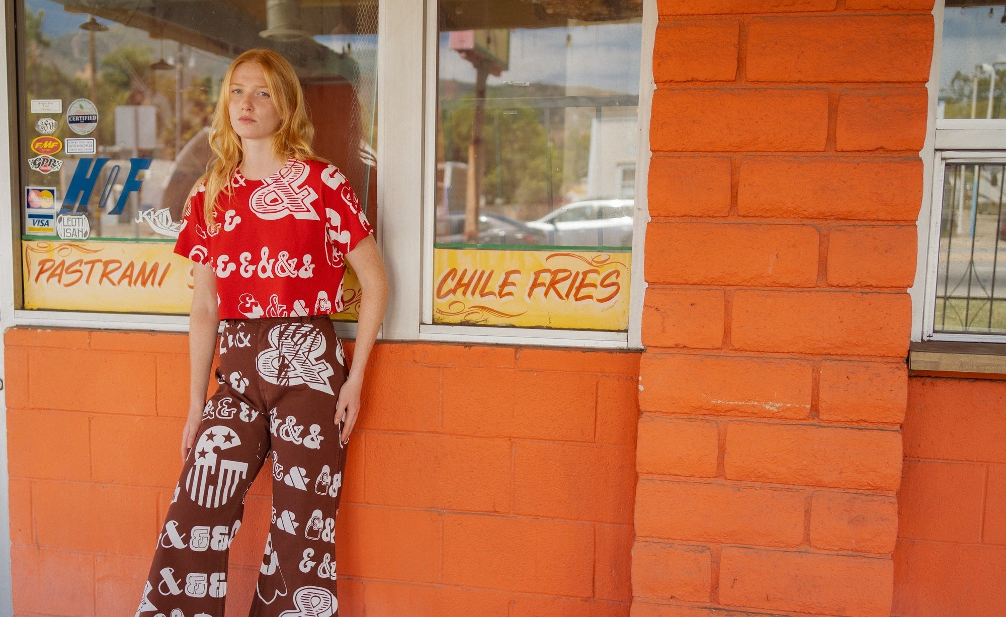 Margaret is wearing Cropped Burly Tee in Mustang Red and Punctuation Bell Bottoms in Fudgesicle Brown