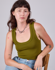 Alex is 5'8" and wearing P Cropped Tank Top in Olive Green