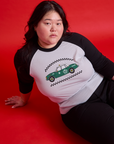 Ashley is wearing a Taxi Raglan Tee in Los Angeles. White body with black sleeves.
