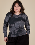 Ashley is 5’7” and wearing L Long Sleeve Baby Tee in Black Magic Waters