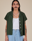 Anthony is 5’6” and wearing S Pantry Button-Up in Swamp Green