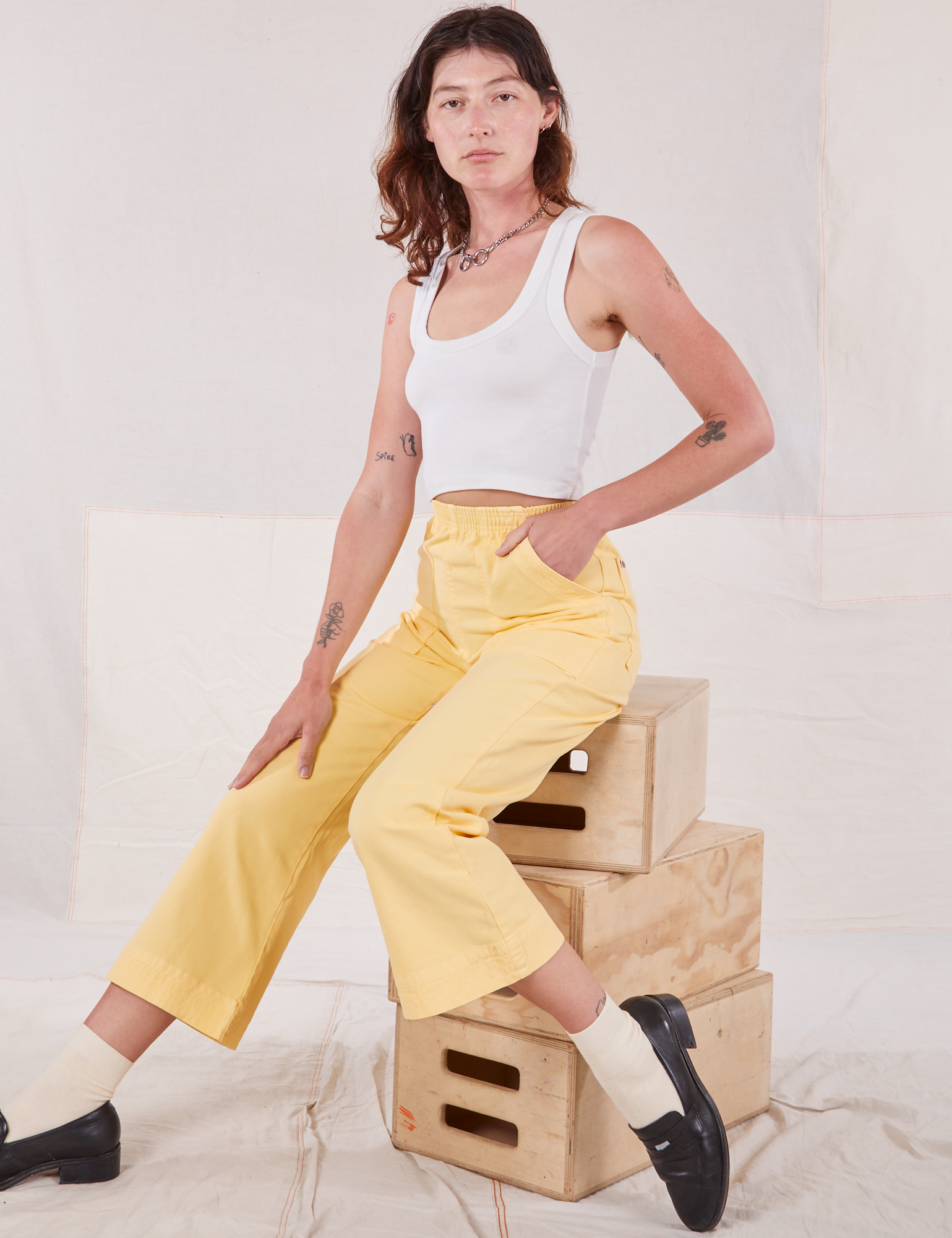 Alex is wearing Action Pants in Butter Yellow and Cropped Tank in vintage tee off-white