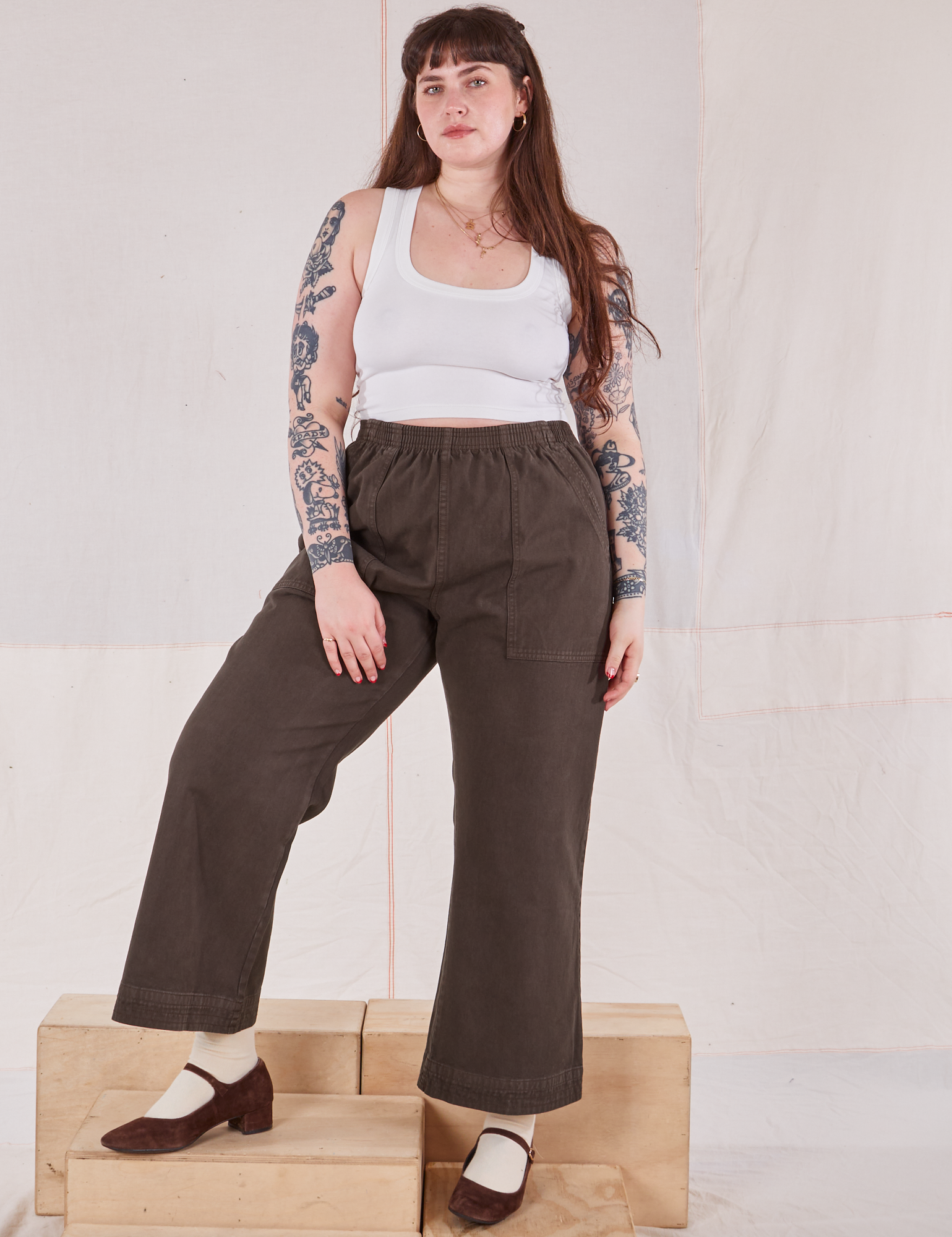 Sydney is 5'9" and wearing L Action Pants in Espresso Brown paired with Cropped Tank in vintage tee off-white
