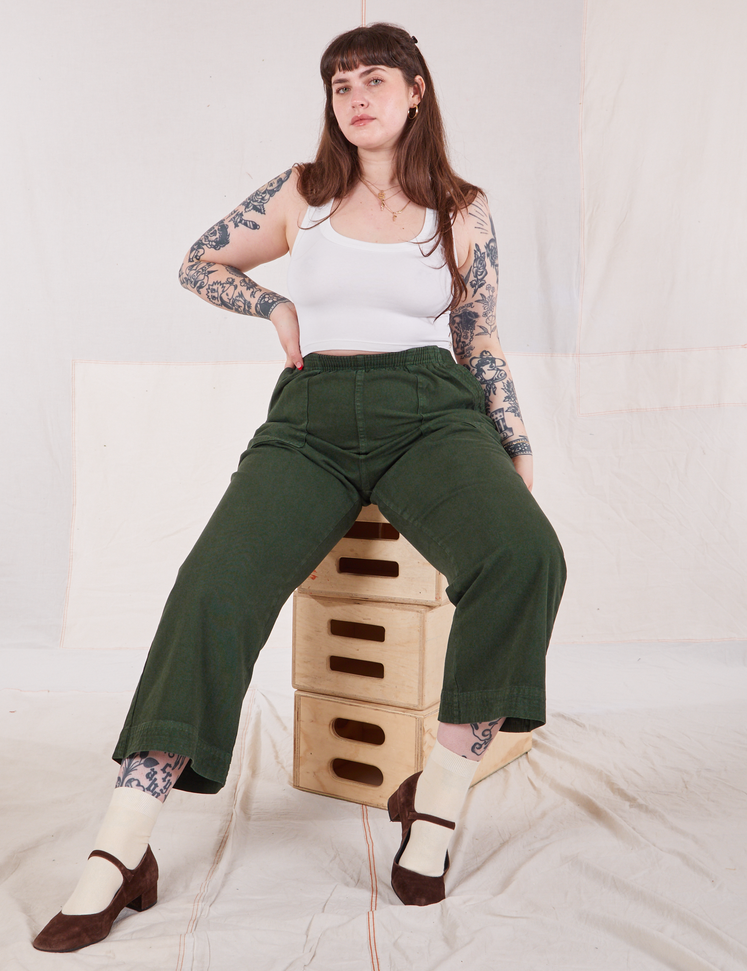 Sydney is wearing Action Pants in Swamp Green and Cropped Tank in vintage tee off-white