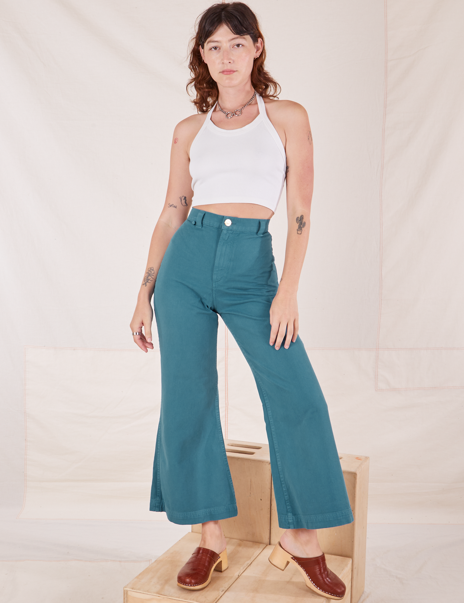 Alex is 5&#39;8&quot; and wearing XXS Bell Bottoms in Marine Blue paired with Halter Top in vintage tee off-white