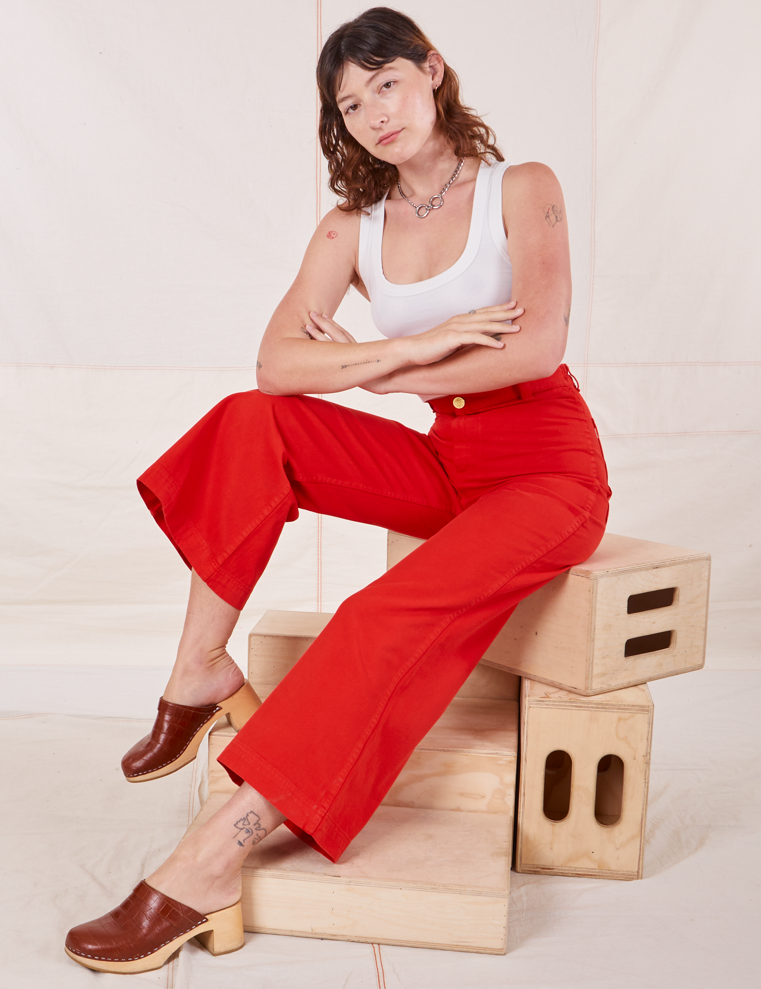 Alex is wearing Bell Bottoms in Mustang Red and vintage off-white Cropped Tank Top