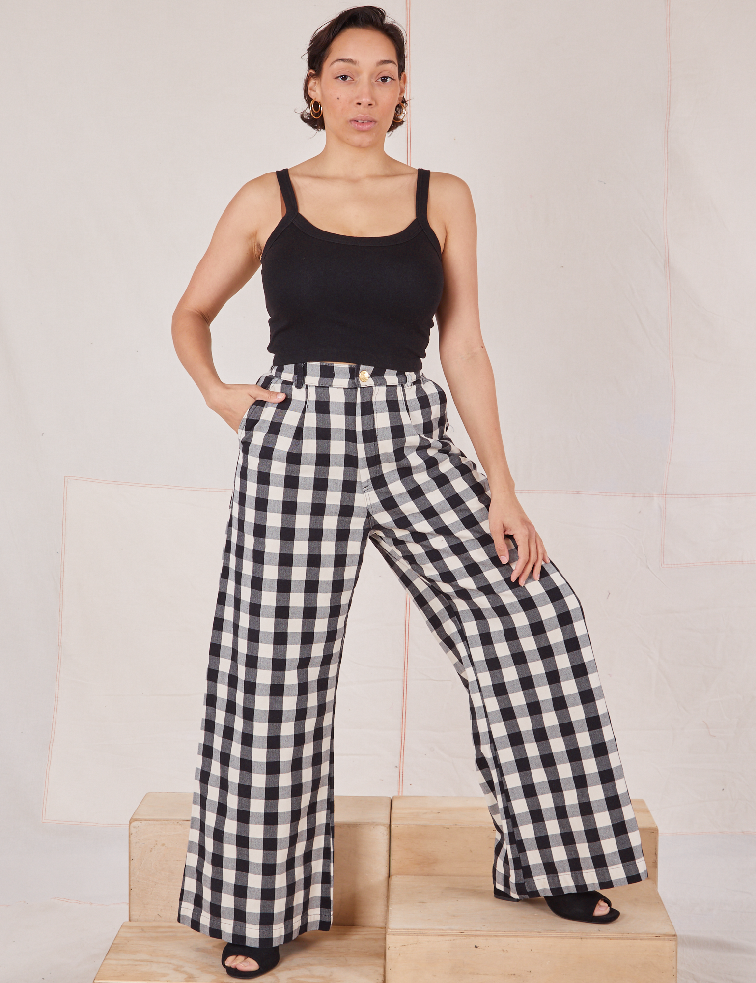 Tiara is 5'4" and wearing XS Wide Leg Trousers in Big Gingham paired with black Cropped Cami