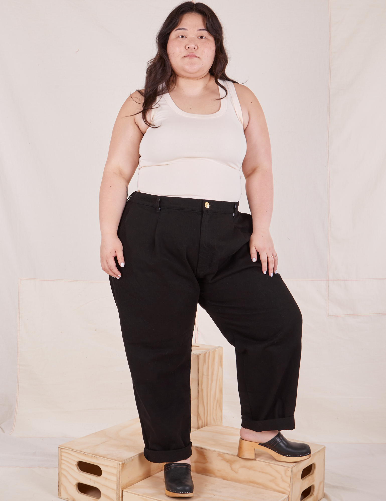 Ashley is 5'7" and wearing 1XL Denim Trouser Jeans in Black paired with Tank Top vintage tee off-white