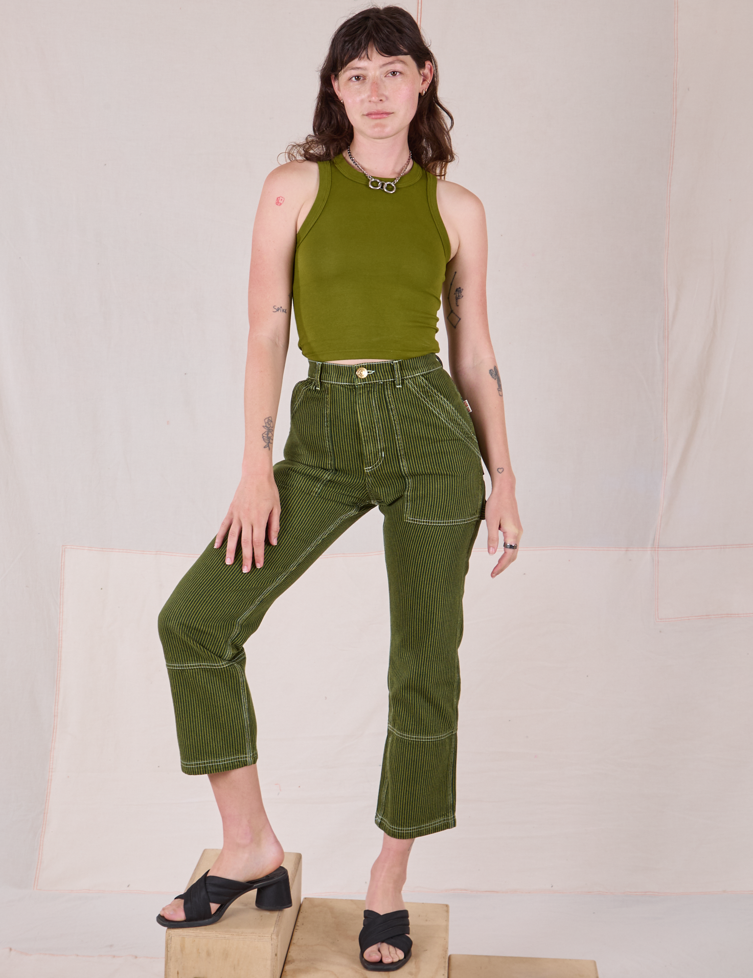 Alex is 5’8” and wearing XXS Railroad Carpenter Jeans in Summer Olive paired with summer olive Muscle Tee