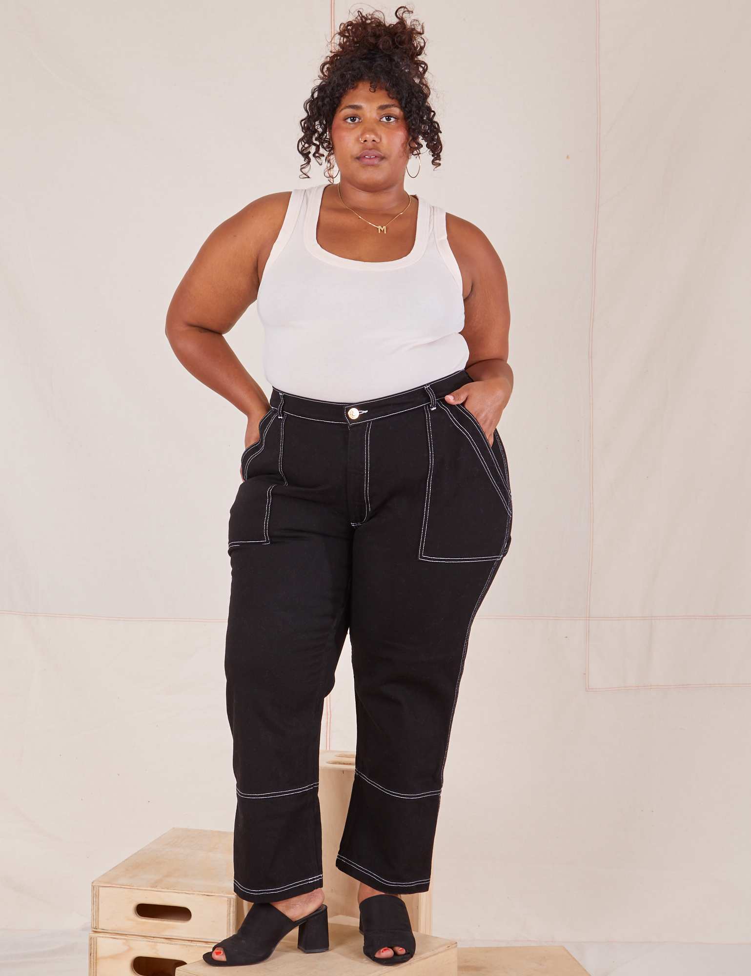 Morgan is 5&#39;5&quot; and wearing 1XL Carpenter Jeans in Black paired with Tank Top in vintage tee off-white