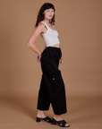 Side view of Drop Pocket Cargo Pants in Basic Black worn by Alex