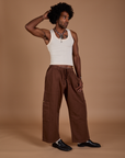 Jerrod is 6’3” and wearing M Drop Pocket Cargo Pants in Fudgesicle Brown paired with a Tank Top in vintage tee white