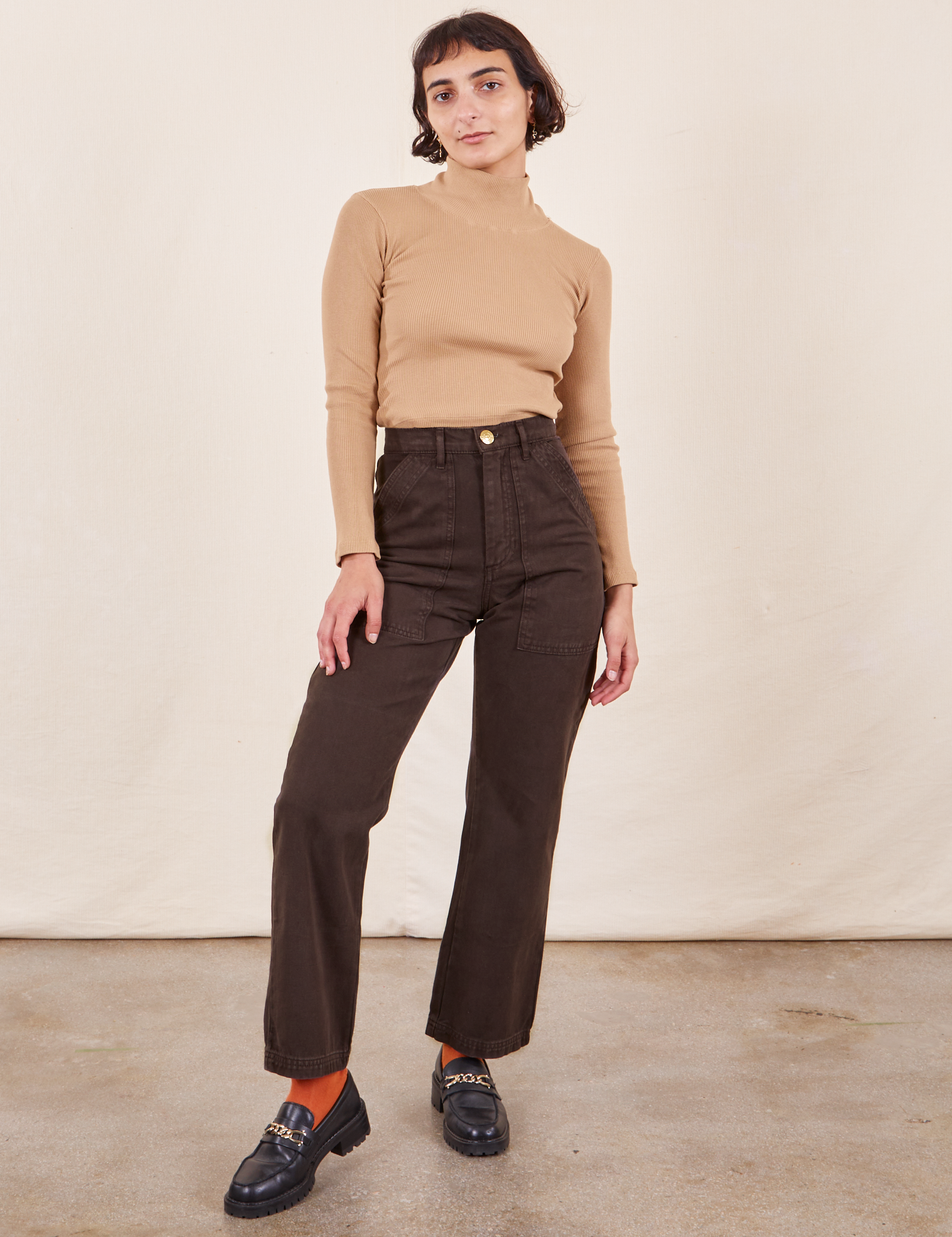 Soraya is 5&#39;2&quot; and wearing Petite XXS Work Pants in Espresso Brown paired with Essential Turtleneck in Tan