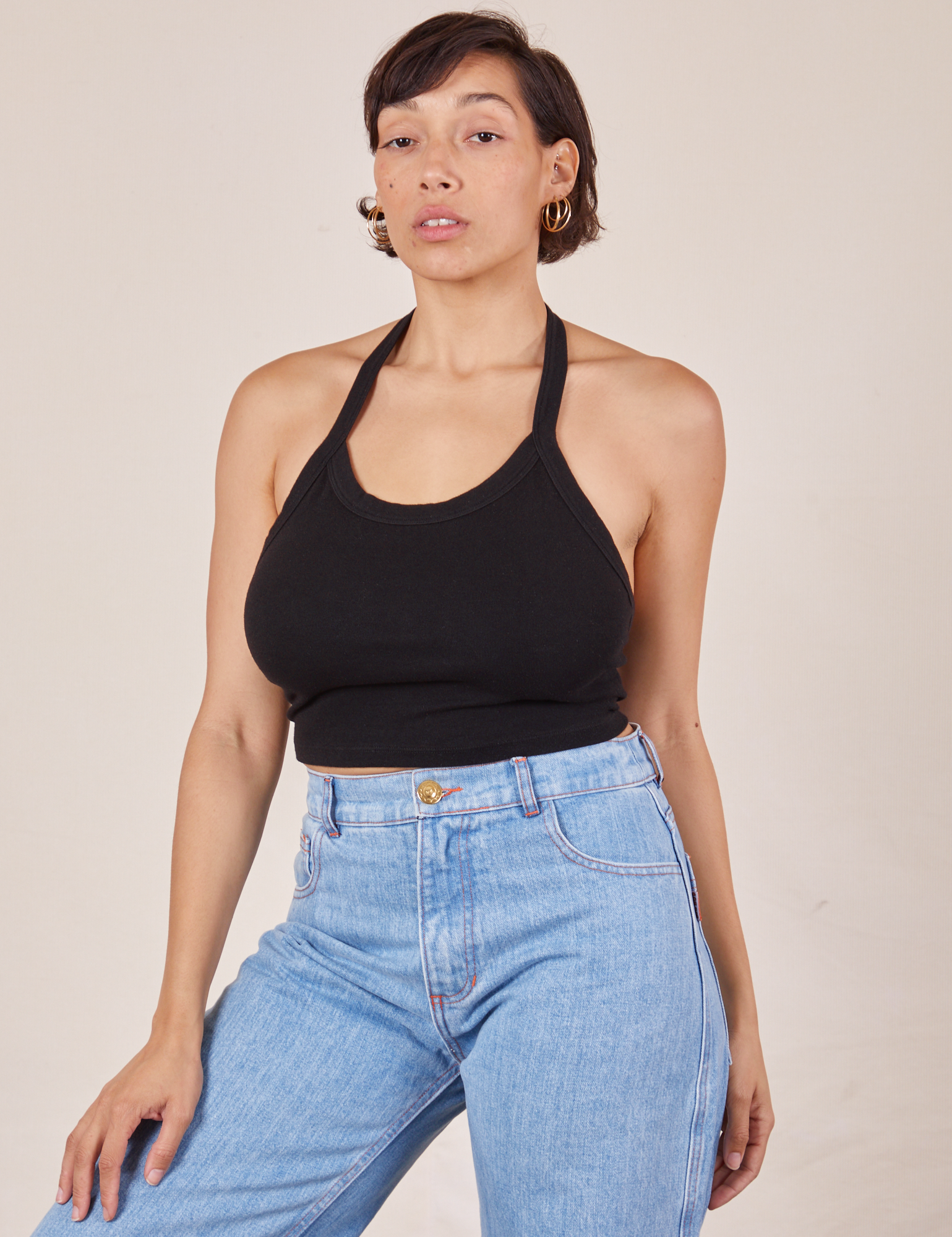 Tiara is 5&#39;4&quot; and wearing XS Halter Top in Basic Black paired with light wash Sailor Jeans