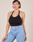 Tiara is 5'4" and wearing XS Halter Top in Basic Black paired with light wash Sailor Jeans