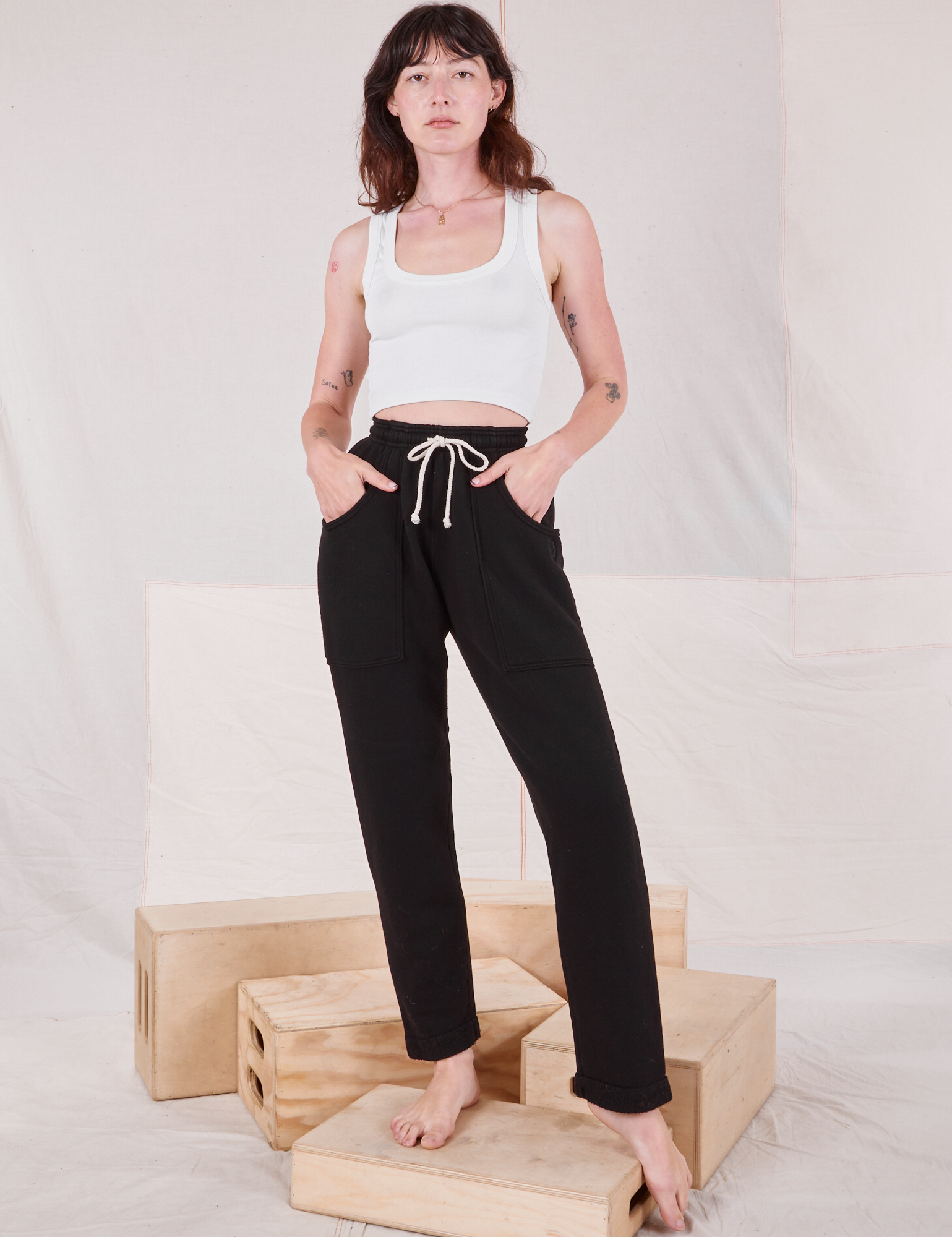 Alex is 5&#39;8&quot; and wearing P Rolled Cuff Sweat Pants in Basic Black paired with Cropped Tank in  vintage tee off-white 