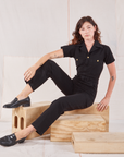 Alex is wearing Heritage Short Sleeve Jumpsuit in Basic Black