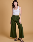 Alex is 5'8" and wearing XXS Heritage Wide Leg Trousers in Evergreen paired with a vintage tee white Cropped Tank