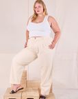 Juliet is 5’7” and wearing 0XL Heritage Trousers in Natural paired with a Cropped Tank in vintage tee off-white