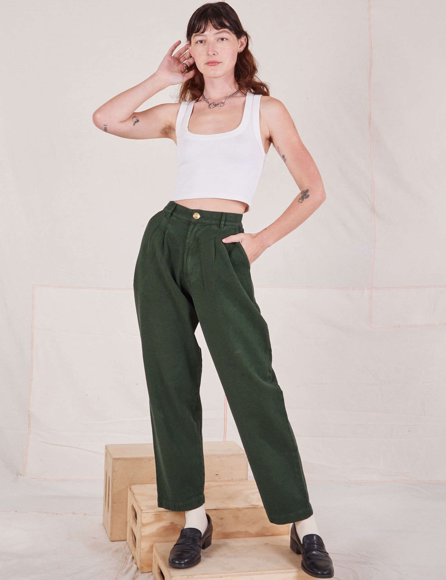 Alex is 5&#39;8&quot; and wearing XXS Heritage Trousers in Swamp Green paired with vintage off-white Cropped Tank Top