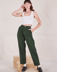 Alex is 5'8" and wearing XXS Heritage Trousers in Swamp Green paired with Cropped Tank Top in vintage tee off-white