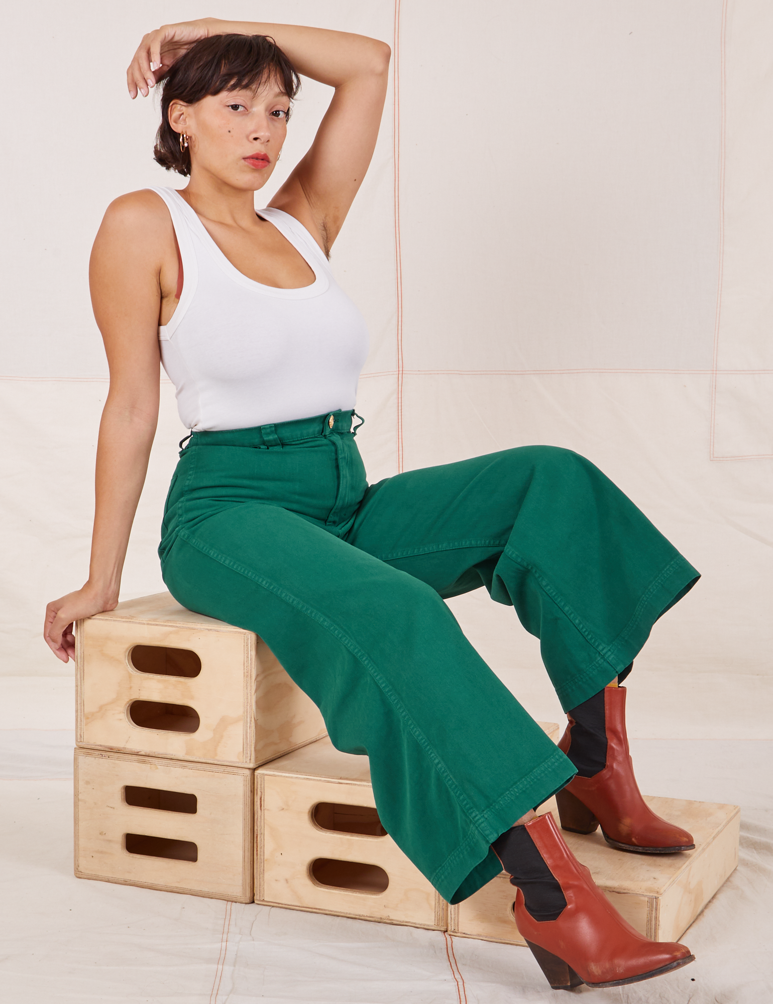 Tiara is wearing Bell Bottoms in Hunter Green paired with a Tank Top in vintage tee off-white