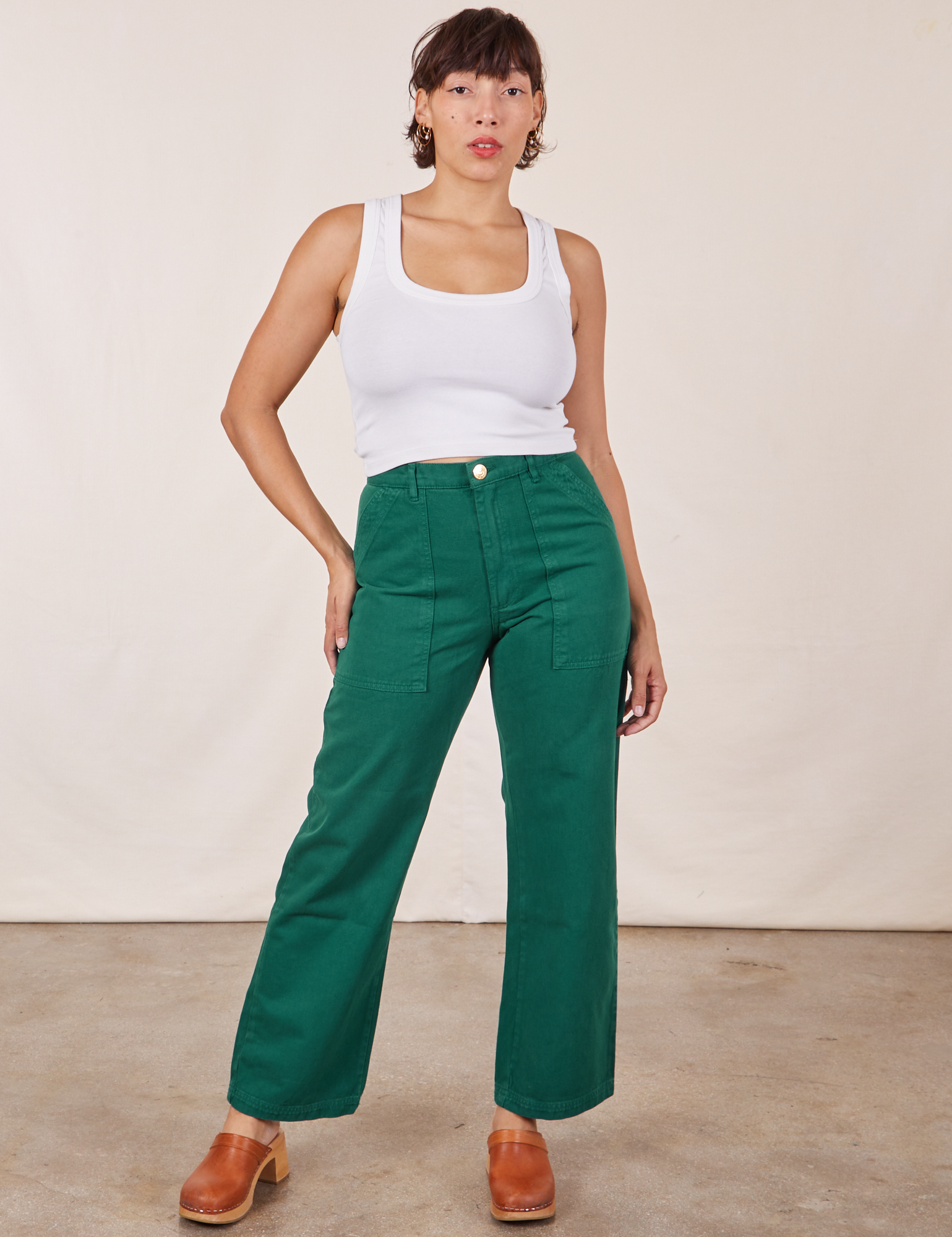 Tiara is 5&#39;5&quot; and wearing S Work Pants in Hunter Green paired with Cropped Tank Top in vintage tee off-white
