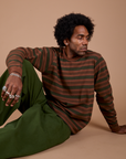 Jerrod is wearing Long Sleeve Striped Burly Tee in Fudgesicle paired with Drop Pocket Cargo Pants in Evergreen