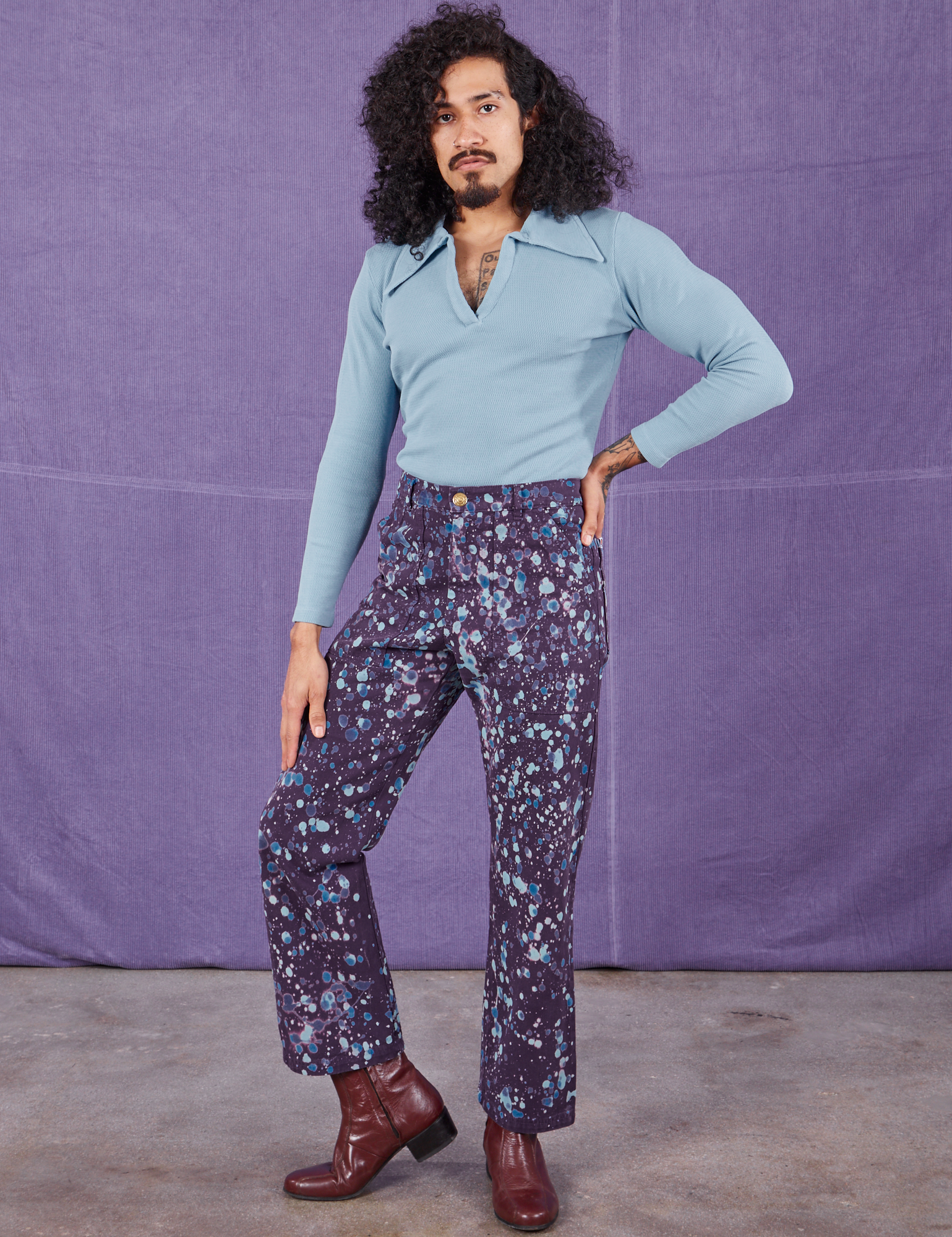 Jesse is 5&#39;8&quot; and wearing XS Marble Splatter Work Pants in Nebula Purple paired with baby blue Long Sleeve Fisherman Polo