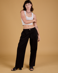 Alex is 5'8" and wearing XXS Baggy Mid-Rise Trousers in Basic Black paired with a vintage tee white Cropped Tank