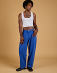 Jerrod is 6'3" and wearing M Baggy Mid-Rise Trousers in Royal Blue paired with vintage tee white Cropped Tank