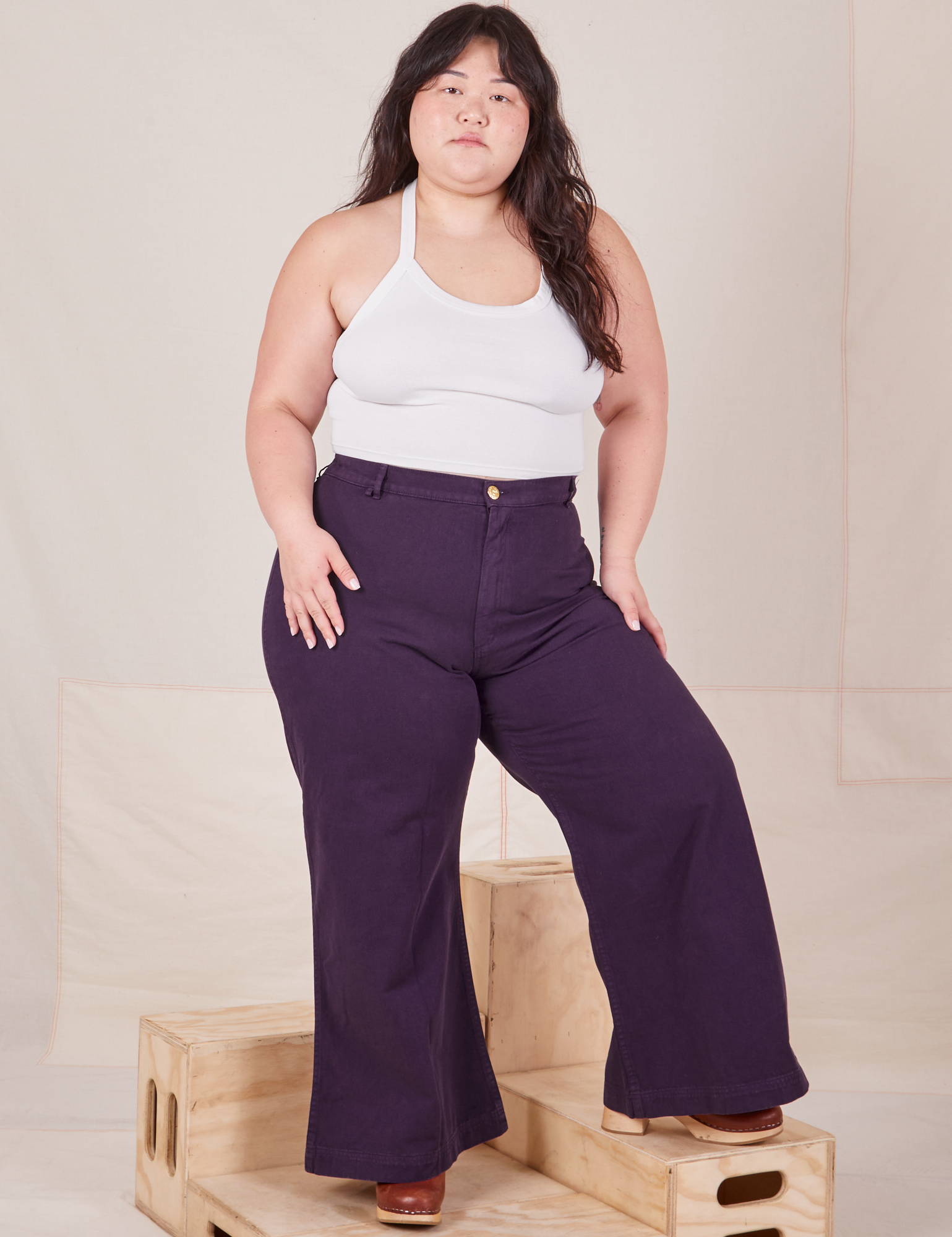 Ashley is 5'7" and wearing 1XL Bell Bottoms in Nebula Purple paired with Halter Top in vintage tee off-white