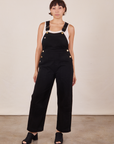 Tiara is 5'4" and wearing size XS Original Overalls in Mono Black with a Cropped Tank Top in vintage tee off-white  underneath.