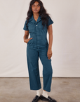 Kandia is 5'3" and wearing XS Petite Short Sleeve Jumpsuit in Lagoon