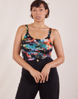Tiara is 5'4" and wearing XS Cropped Cami in Rainbow Magic Waters paired with black Western Pants