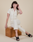 Alex is wearing Short Sleeve Jumpsuit in Vintage Tee White