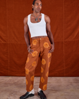 Jerrod is 6'3" and wearing M Paintstamped Work Pants in Orange paired with a Cropped Tank in vintage tee off-white
