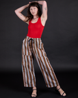 Alex is 5’8” and wearing XXS Striped Drop Pocket Pants in Retro Rainbow paired with mustang red Racerback Tank
