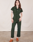 Hana is 5’3” and wearing XXS Petite Short Sleeve Jumpsuit in Swamp Green