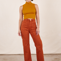 Soraya is 5'2" and wearing Petite XXS Work Pants in Burnt Terracotta paired with Sleeveless Turtleneck in Spicy Mustard