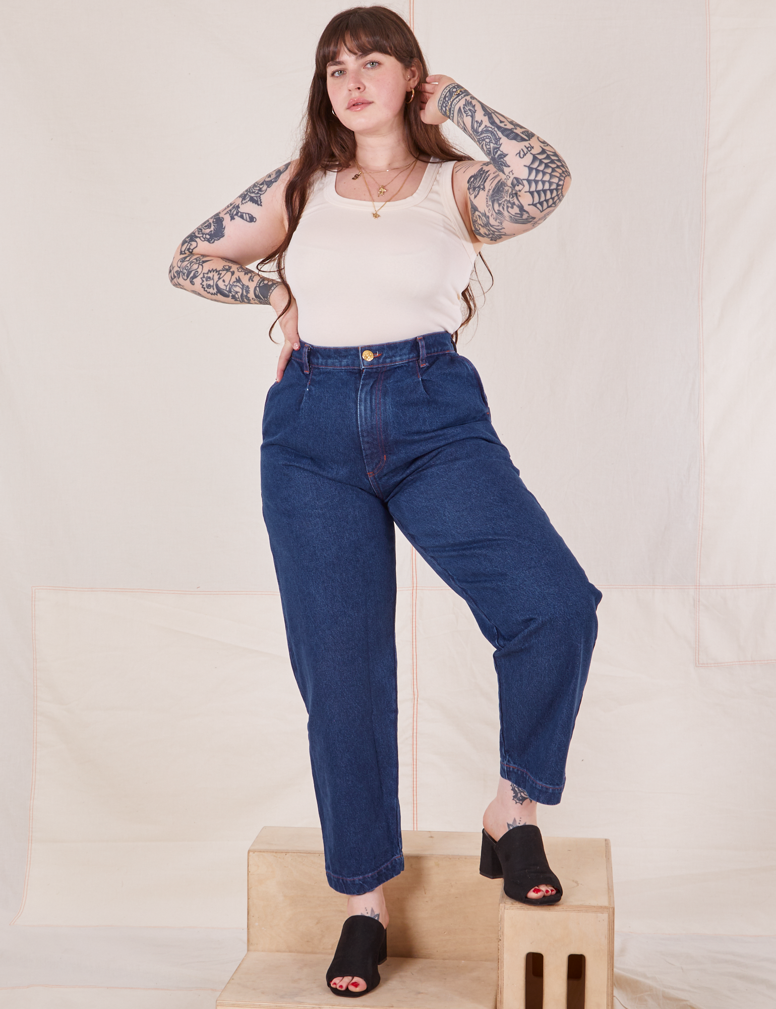 Sydney is 5&#39;9&quot; and wearing M Denim Trouser Jeans in Dark Wash paired with Tank Top in vintage Tee off-white
