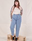 Sydney is 5'9" and wearing M Denim Trouser Jeans in Light Wash paired with vintage off-white Tank Top