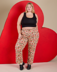 Juliet is 5’7” and wearing 1XL Work Pants in Hot Stuff Print paired with a black Cropped Tank